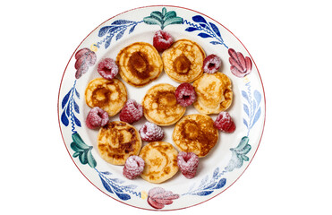 Plate with traditional dutch poffertjes, also called as mini pancakes, with raspberries and powdered sugar isolated on white