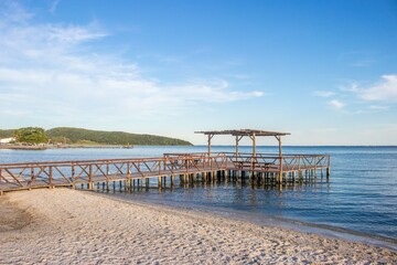 Rustic Wooden Pier on a Serene Beach at Sunset