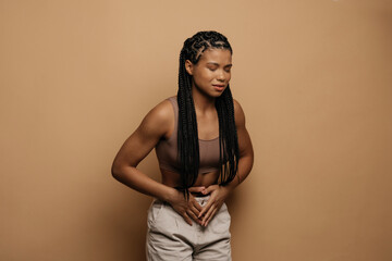 Food poisoning. Troubled african american woman touching stomach, suffering from abdominal pain or...