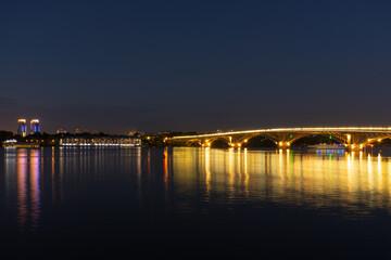 night cityscape on the water near the bridge
