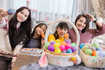 Woman and kids celebrating Easter with colorful eggs