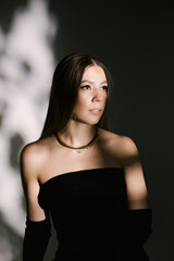 Portrait of a woman in a studio with professional lighting in a smart dress with gloves