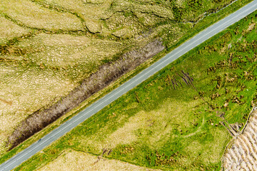 Aerial view of endless lush pastures and farmlands of Ireland. Beautiful Irish countryside with emerald green fields and meadows.