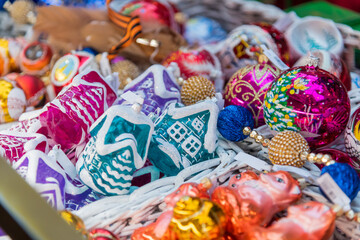 Colorful handmade ornaments displayed in a market basket during a festive season celebration