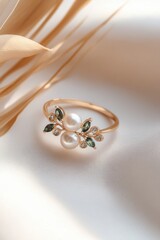 Elegant pearl cluster ring featuring green crystals and gold accent on a soft neutral background