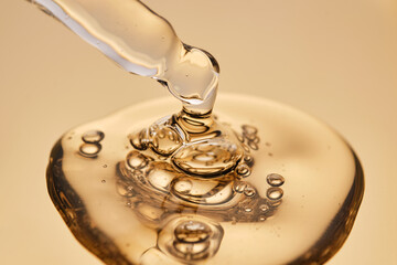 A pipette with a beautiful drop of gel-textured facial serum.