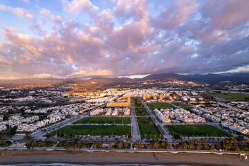 Clouds over wide aerial panorama of Costa del Sol coastline Mediterranean Spanish destination Marbella with boulevard of San Pedro de Alcantara against a sunrise sky