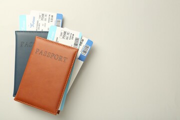 Passports with tickets on light background, top view. Space for text