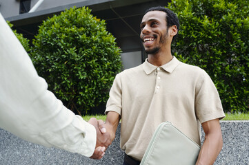 Happy businessman shaking hands to his colleague in the city