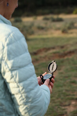 Woman with a compass in her hands in a clearing