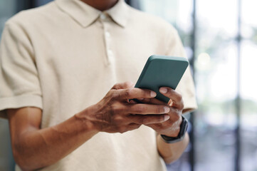 Close-up of businessman texting message on his smartphone and communicating online