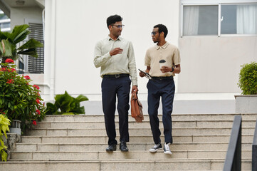 Fototapeta premium Colleagues talking to each other while walking in city
