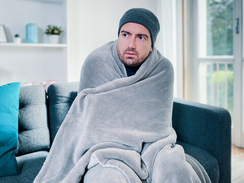 Man feeling cold at home with home heating trouble