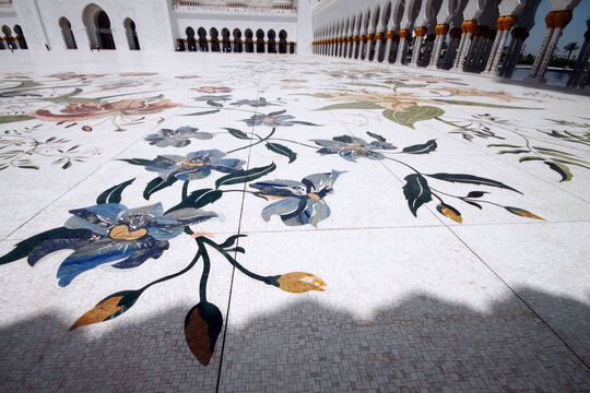 Blick auf den mit Ornamenten verzierten Gebetsplatz und S&Atilde;&curren;uleng&Atilde;&curren;nge der Sheikh Zayed-Moschee in Abu Dhabi in den Vereinigten Arabischen Emiraten.