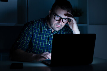 Portrait of shocked man reading bad news on laptop