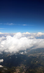 Obraz premium aerial view of white clouds from an airplane in flight and the land
