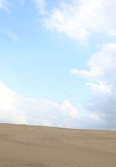 natural background with desert dune sand and a cloudy sky above