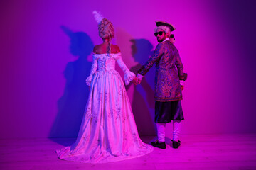 Elegant couple in vintage costumes dancing in neon-lit environment with vibrant purple hues symbolizing retro allure and carnival themes