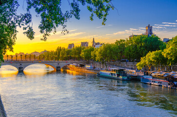 Paris cityscape of historic city center, Pont Louis-Philippe bridge across Seine river, tourist ships near quay Hotel de ville, Voie Georges Pompidou expressway promenade embankment on sunset, France © Aliaksandr