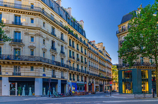 Paris city street in Le Marais historic district, traditional Parisian architecture apartment building with typical facade, balconies and windows iron fences, typical French house on crossroad