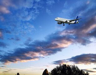 A passenger plane is flying in a beautiful blue sky with white clouds.