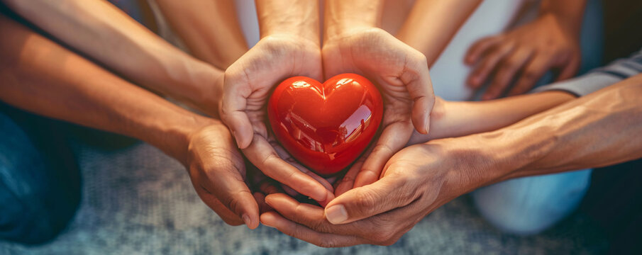United hands holding red heart symbol