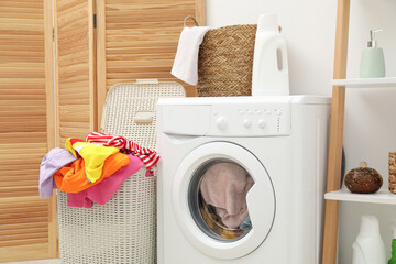Wicker baskets with laundry and washing machine in bathroom