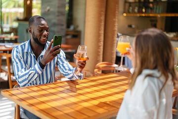 Joyful Couple Taking Photos in Tropical Bar