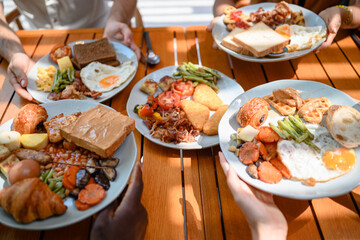 Close up of a colorful breakfast at an outdoor restaurant. Plates are filled with eggs, toast, fresh vegetables, and pastries on a sunny wooden table, creating an lively dining experience.