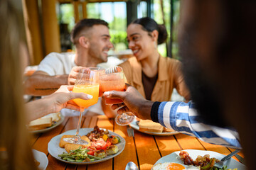 Diverse Friends Toasting with Juice at Breakfast Table