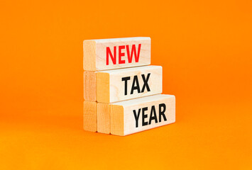 Naklejka premium New tax year symbol. Concept words New tax year on beautiful wooden blocks. Beautiful orange table orange background. Business new tax year concept. Copy space.