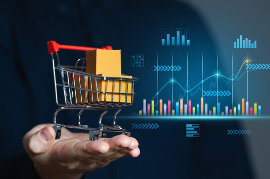 Businessman holding shopping cart with boxes and sales charts. Retail concept and sales statistics. Performance analysis, market trends. Consumer experiences and enhance business efficiency.