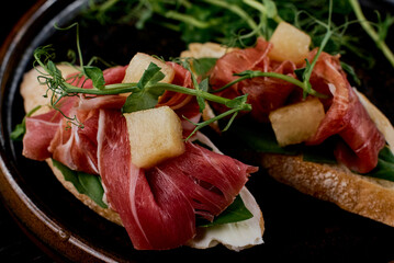 Close-Up of Prosciutto Crostini with Pear and Microgreens.