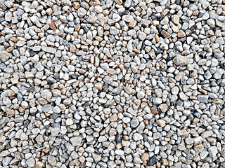 Background filled with colorful, naturally shaped pebbles. Stones of different colors and shades of gray, white, brown and black, natural patterns.