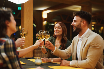 Friends toasting wine glasses celebrating at restaurant reunion