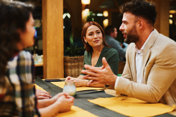 Business people discussing strategy during informal meeting at restaurant