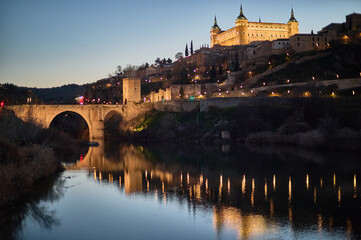 The historic center of Toledo illuminated at night, showcasing its medieval charm and architectural beauty under the night sky in Castilla la Mancha, Spain