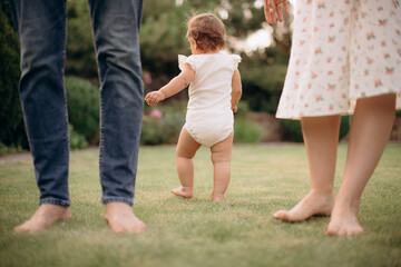 Fototapeta premium family walking in the summer park. father and mother with little baby