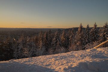 Stunning sunset on mountain in Norway with a magical forest