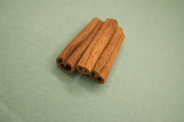 Cinnamon sticks on light green background