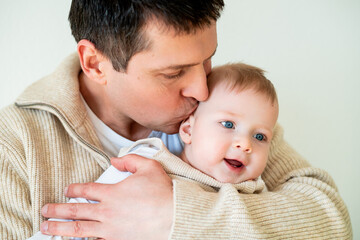 Close-up. Handsome young father hugging his little son.