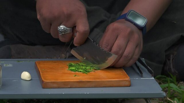 Close up of the activity of an Asian male adventurer cooking lime leaf rice using charcoal and wood. The bushcraft concept makes lime leaf rice with simple equipment in the lush wilderness