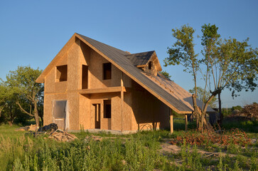 Construction of a new energy-efficient SIP house with a timber frame. Unfinished Wood residential building of panelized wall in country area.