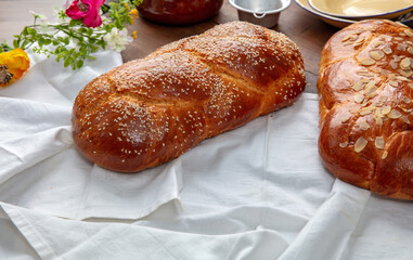 Easter sweet bread, two tsoureki braids on white table cloth, closeup
