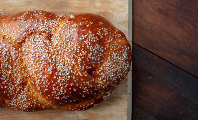Easter sweet bread, homemade tsoureki braid on a wooden table, closeup