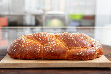 Easter sweet bread, homemade tsoureki braid on a wooden board, closeup