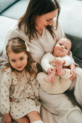 Happy mother and little children in cozy home. Family relationships. Mother's Day.