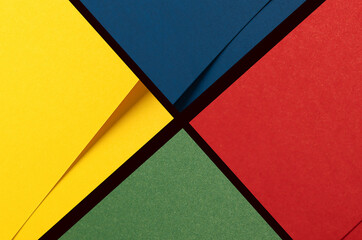 Bold geometric paper background divided into vibrant quadrants of yellow, blue, red, and green....