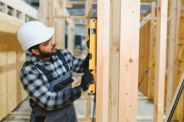 Construction of modular houses. Male indian construction worker in uniform and hard hat at...