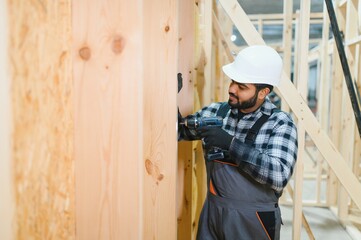 Indian carpenter works on the construction of modular houses
